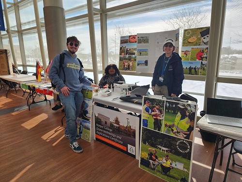 group photo of students by the drone club table in the Avante science building