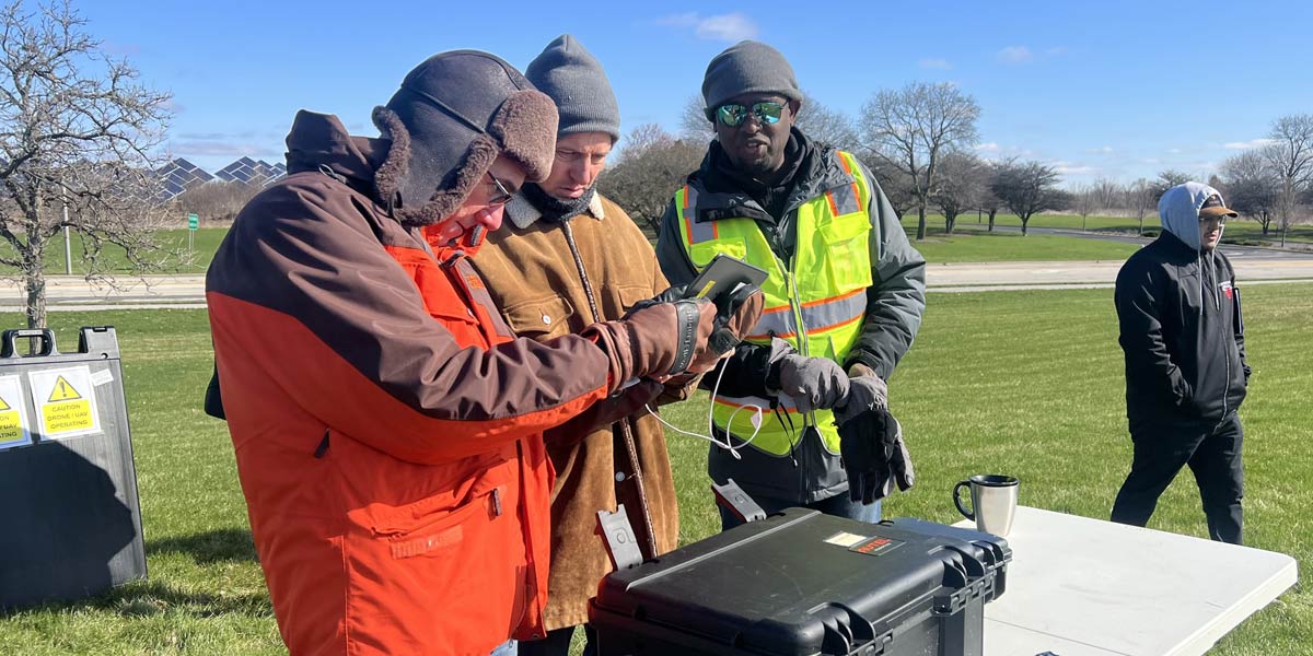 group of people checking drone at a table